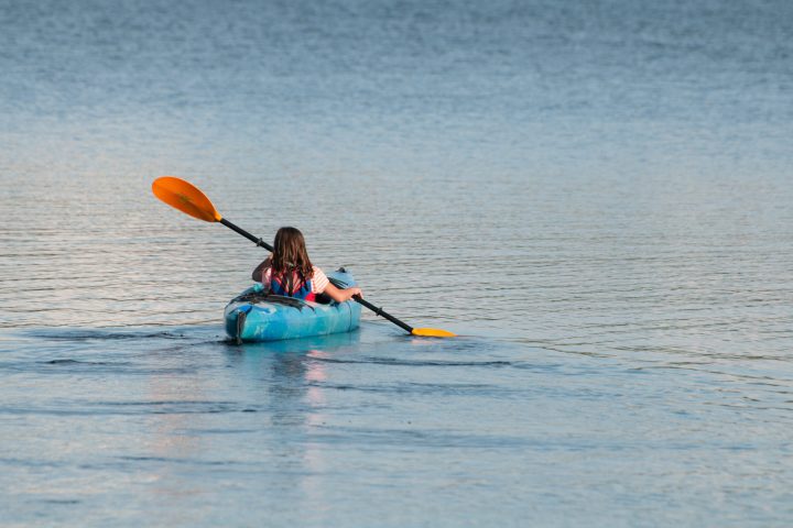 a person holding a frisbee in a body of water