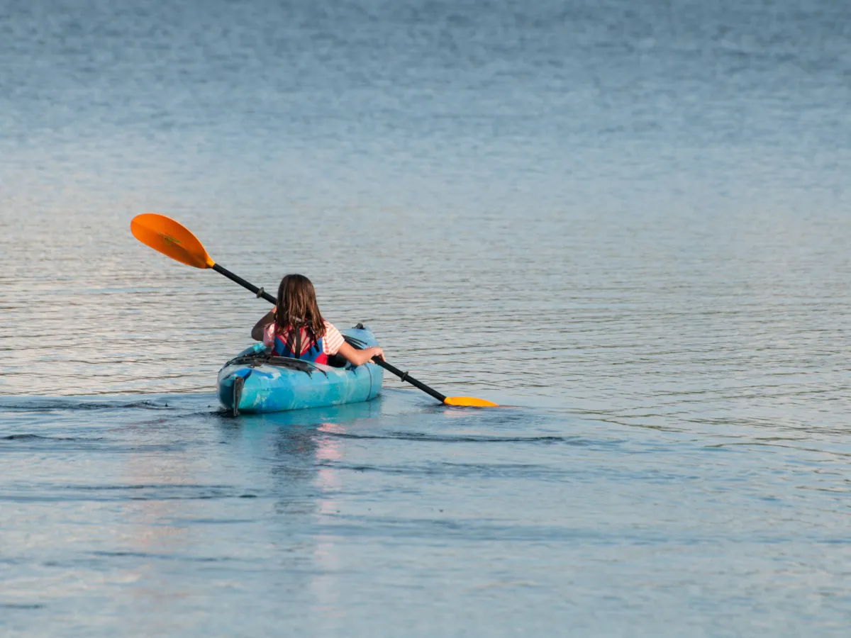 a person holding a frisbee in a body of water
