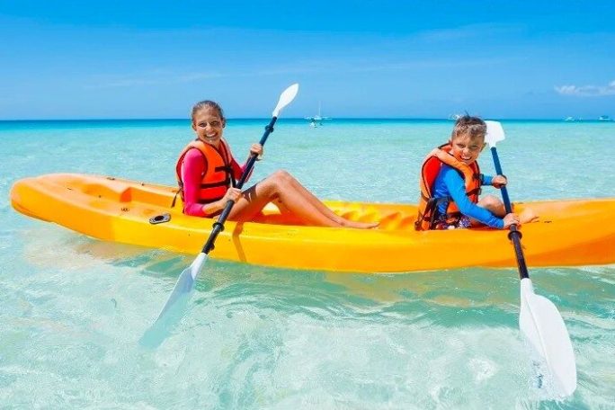 a pair of kids on a tandem kayak